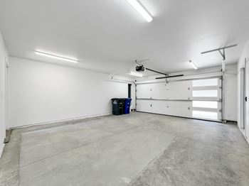 The interior of a garage with a white wall and a garage door